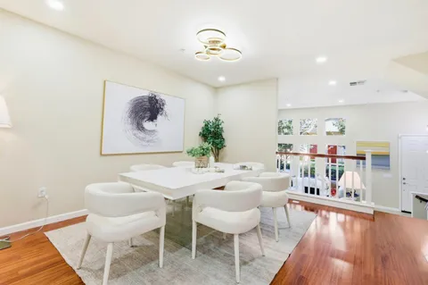 a dining room with wooden floor and a chandelier