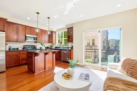 a kitchen with stainless steel appliances granite countertop a refrigerator a sink a stove and a wooden cabinets