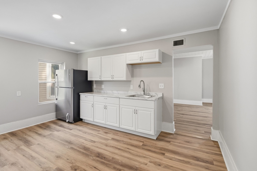 834 Worthington Street, Unit 2 Springfield, MA 01105 - Photo 6 of 20 a kitchen with granite countertop white cabinets and stainless steel appliances