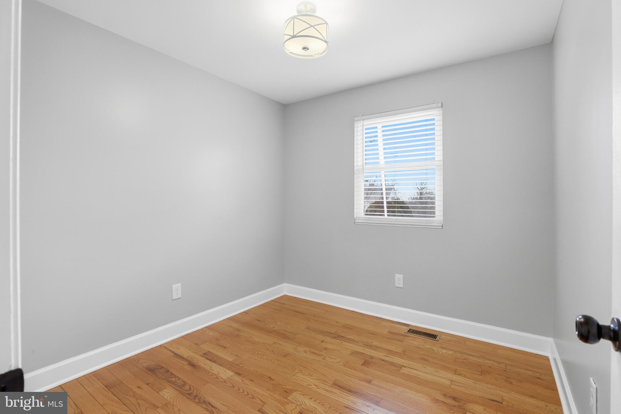 211 Jack Street Baltimore, MD 21225 - Photo 13 of 29 a view of an empty room with wooden floor and a window