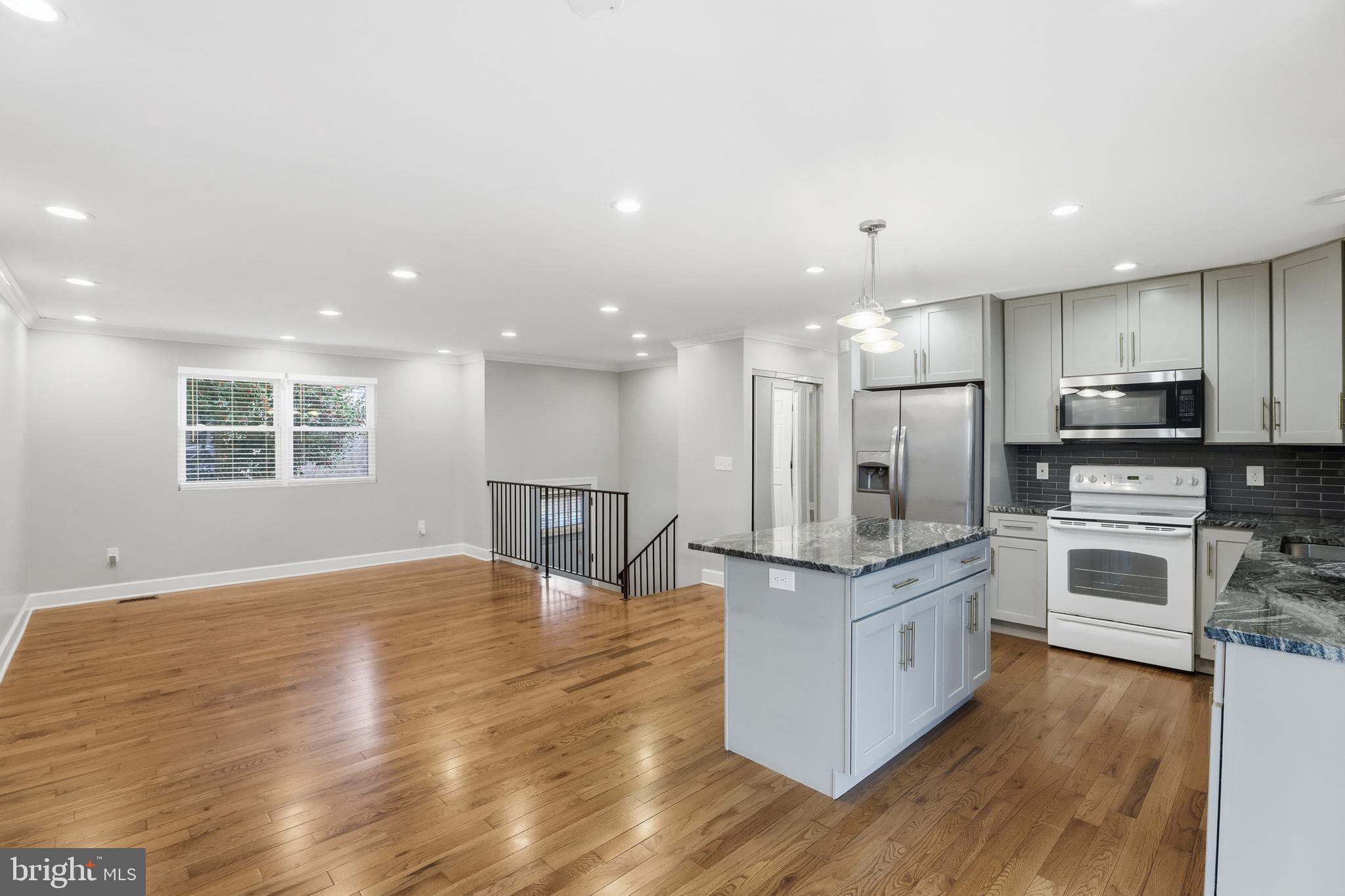 211 Jack Street Baltimore, MD 21225 - Photo 7 of 29 a kitchen with stainless steel appliances kitchen island granite countertop a stove top oven a sink and a refrigerator