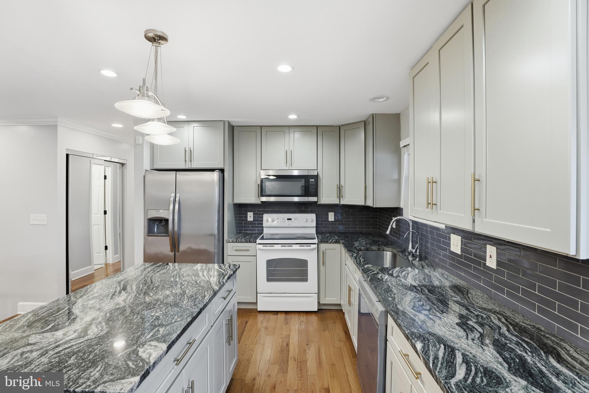 211 Jack Street Baltimore, MD 21225 - Photo 8 of 29 a kitchen with stainless steel appliances granite countertop a stove refrigerator sink and microwave