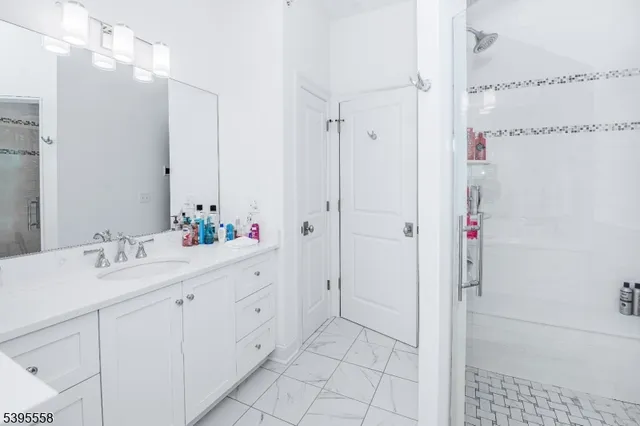 a bathroom with a double vanity sink mirror and shower