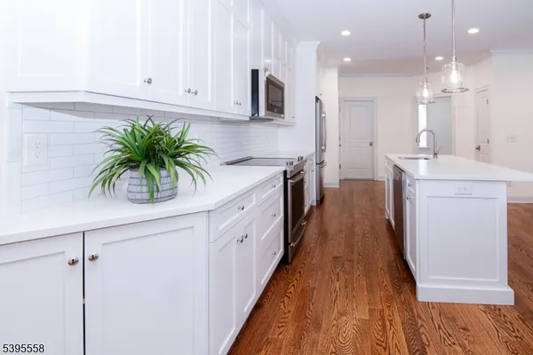 a kitchen with granite countertop a sink a stove and a wooden floors