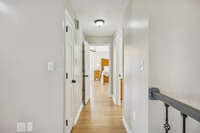 a view of a hallway with wooden floor and staircase