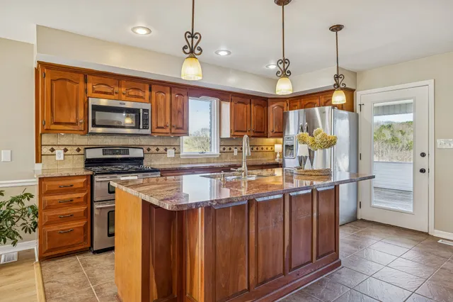 a dining room with furniture a chandelier and wooden floor