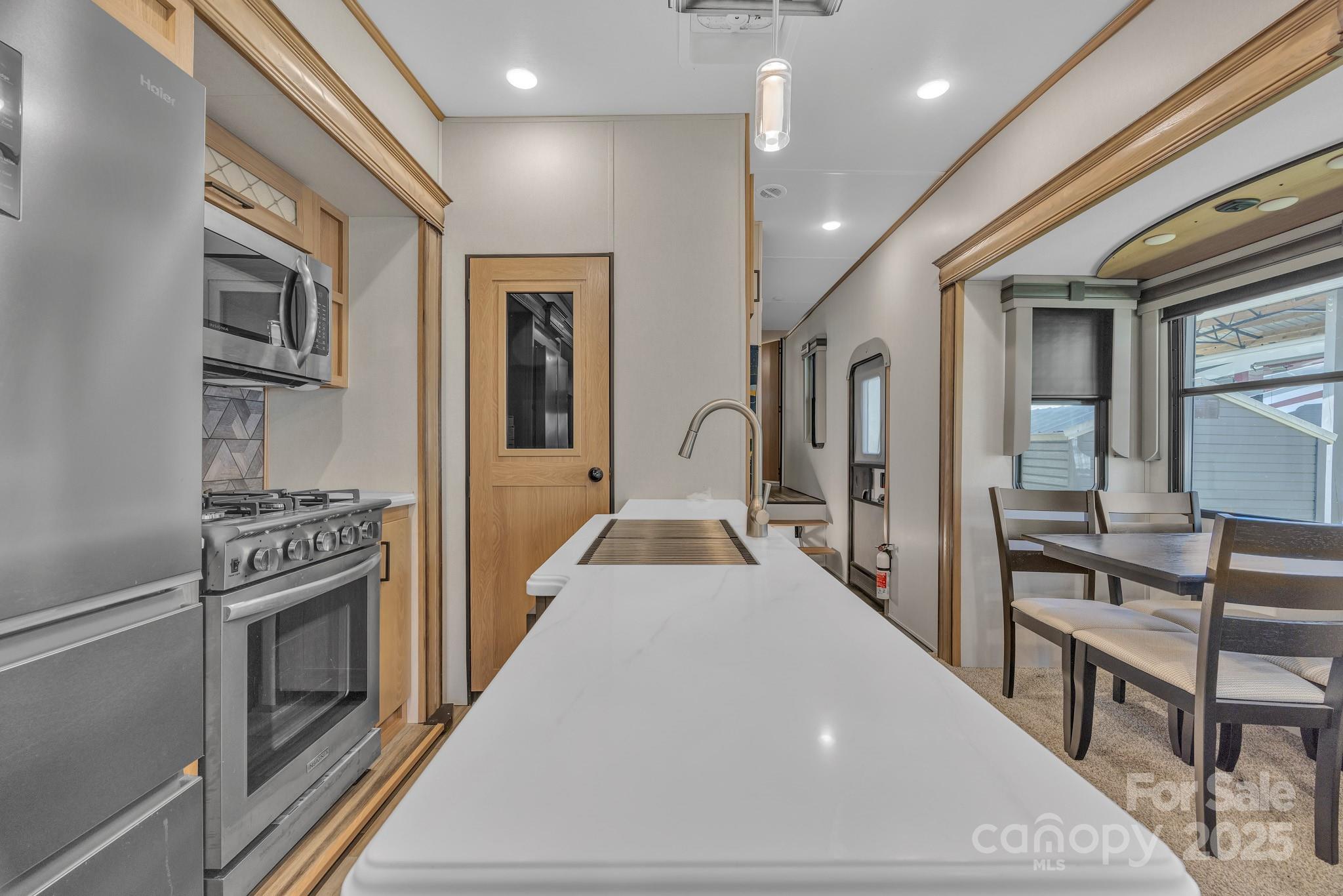 195 Finch Way, Unit 7 West Jefferson, NC 28694 - Photo 13 of 39 a view of a kitchen with kitchen island wooden floor center island stainless steel appliances wooden floor and living room view