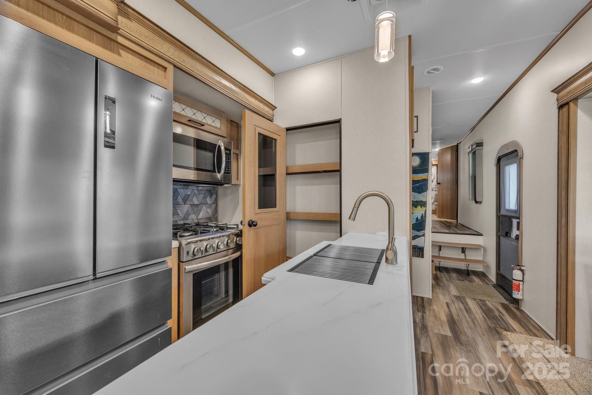 195 Finch Way, Unit 7 West Jefferson, NC 28694 - Photo 16 of 39 a kitchen with stainless steel appliances granite countertop a refrigerator a stove and a sink with wooden floor