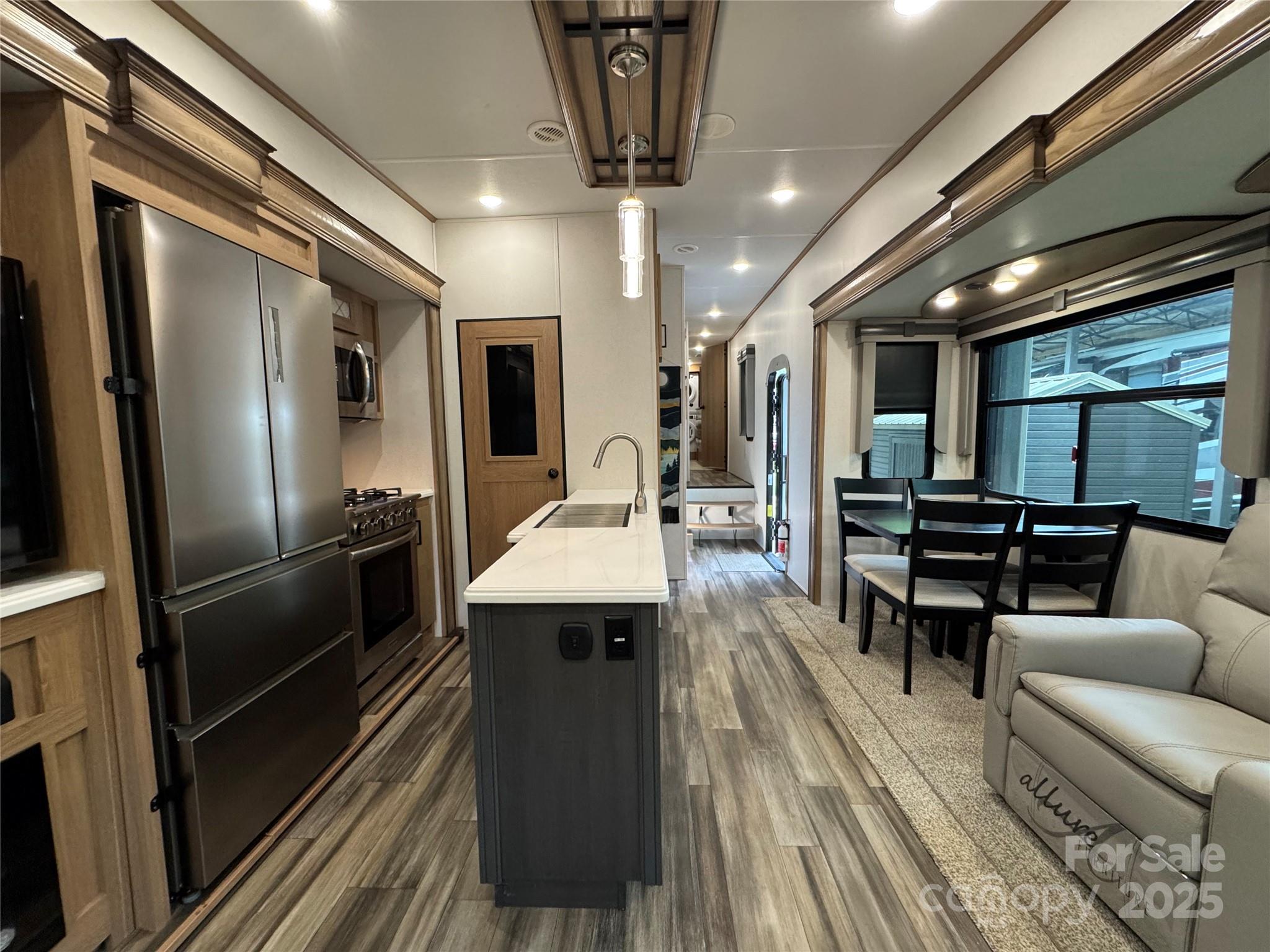 195 Finch Way, Unit 7 West Jefferson, NC 28694 - Photo 10 of 39 a kitchen with stainless steel appliances kitchen island granite countertop a refrigerator a stove and a sink with wooden floor