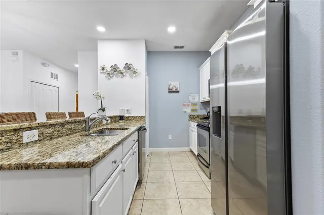 a kitchen with a sink refrigerator and microwave