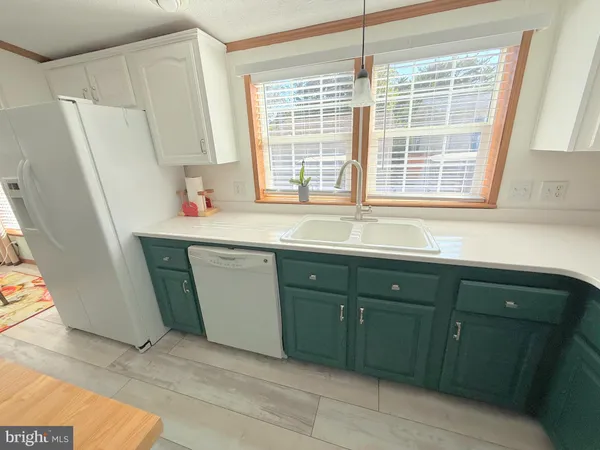 a living room with stainless steel appliances furniture a rug and a fireplace