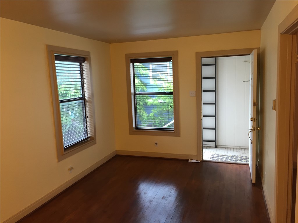 611 West 37th Street, Unit B Austin, TX 78705 - Photo 2 of 9 a view of an empty room with wooden floor and a window