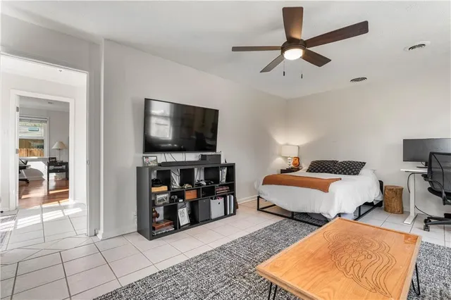 a bedroom with bed and a flat tv screen on dresser