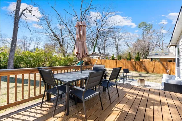 a roof deck with table and chairs and wooden floor