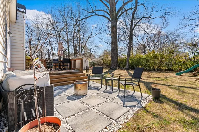 a backyard of a house with barbeque oven table and chairs