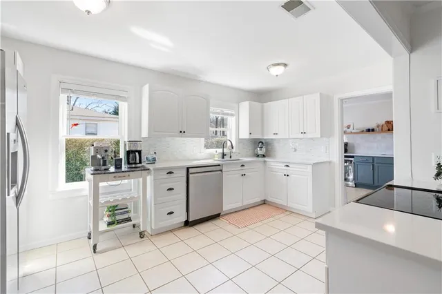 a kitchen with white cabinets and white appliances