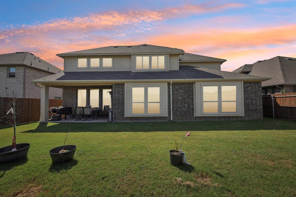 2808 Richard Street Burleson, TX 76028 - Photo 37 of 40 Back of property at dusk featuring a fenced backyard, brick siding, a patio, and a shingled roof