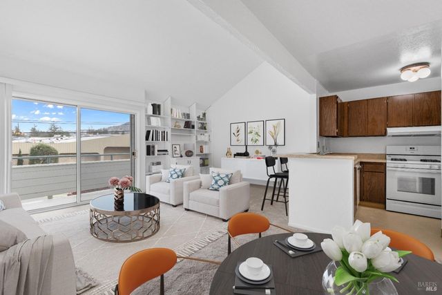 a living room with furniture and a view of kitchen