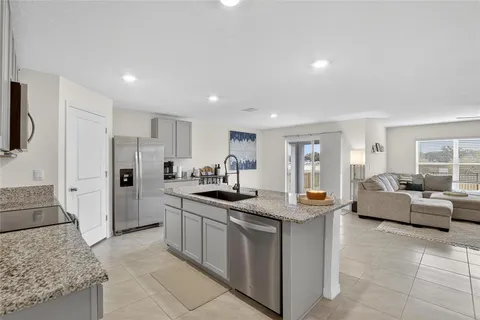 a kitchen with stainless steel appliances granite countertop a sink and a refrigerator