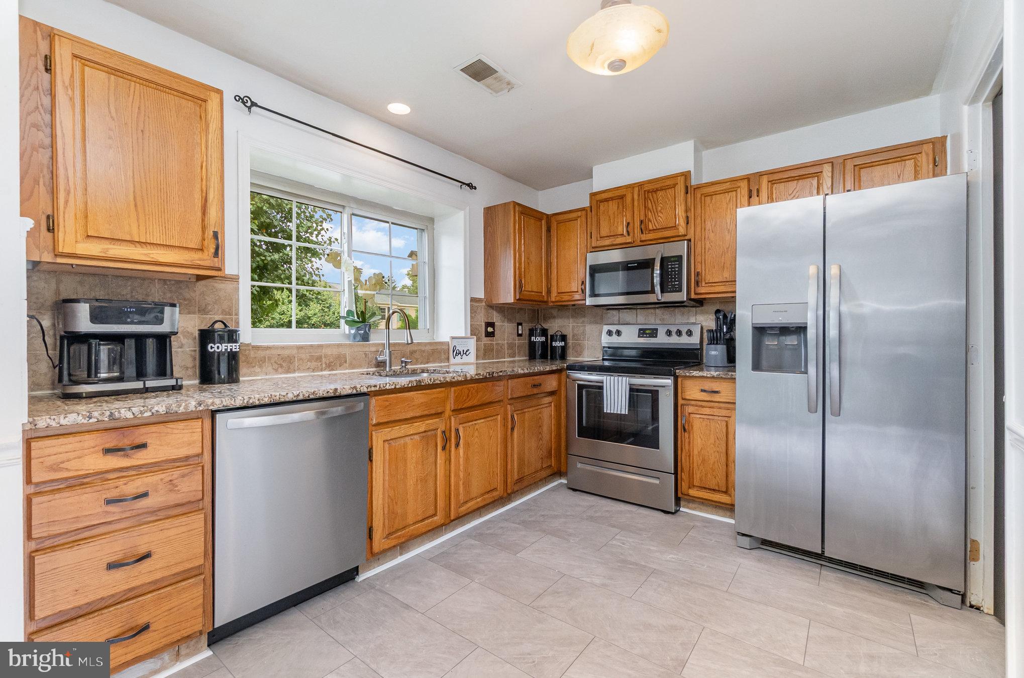 22 Bryce Court Baltimore, MD 21236 - Photo 5 of 28 a kitchen with stainless steel appliances granite countertop a refrigerator a stove a sink and a microwave