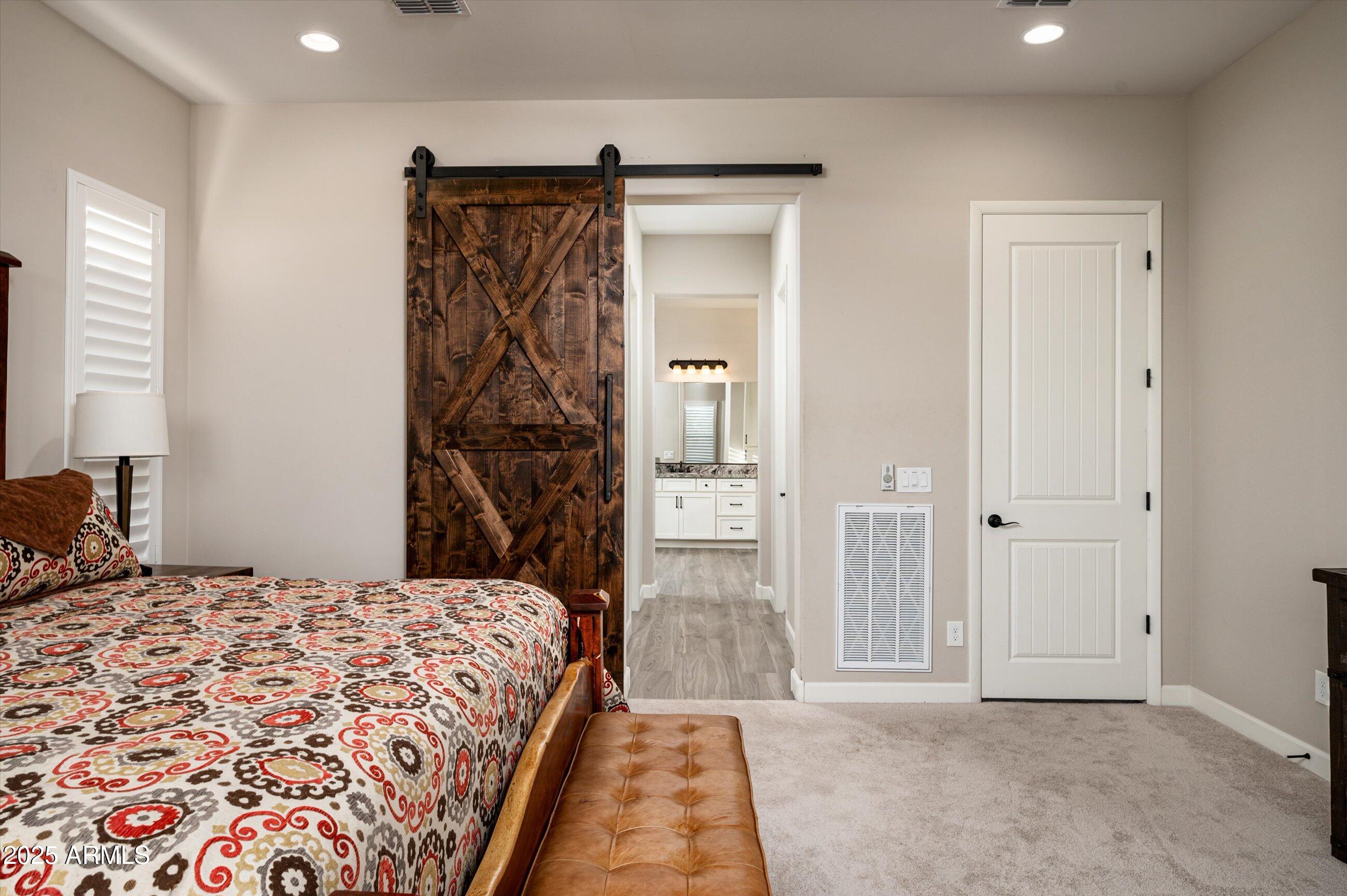 17971 East Cindercone Road Rio Verde, AZ 85263 - Photo 18 of 58 a bedroom with a bed and a walk in closet with wooden floor
