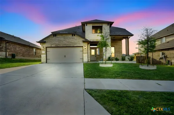 a front view of a house with a yard and garage