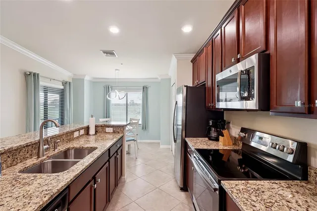 a kitchen with stainless steel appliances granite countertop a sink stove and cabinets