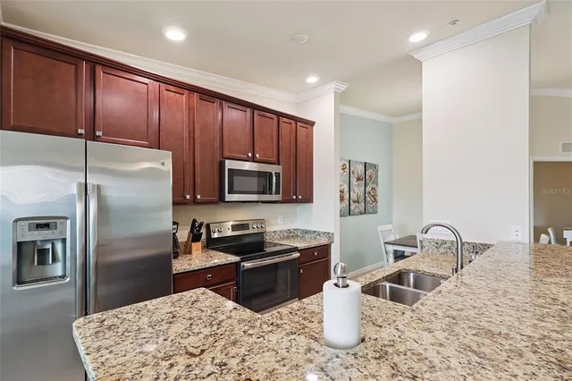 a kitchen with stainless steel appliances granite countertop a sink a stove and a refrigerator