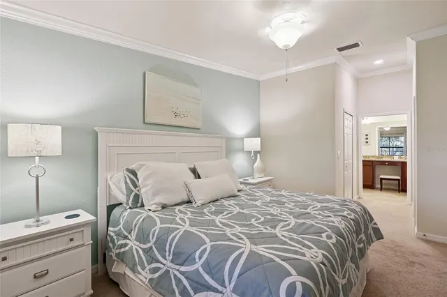 a bedroom with a bed and a lamp on dresser