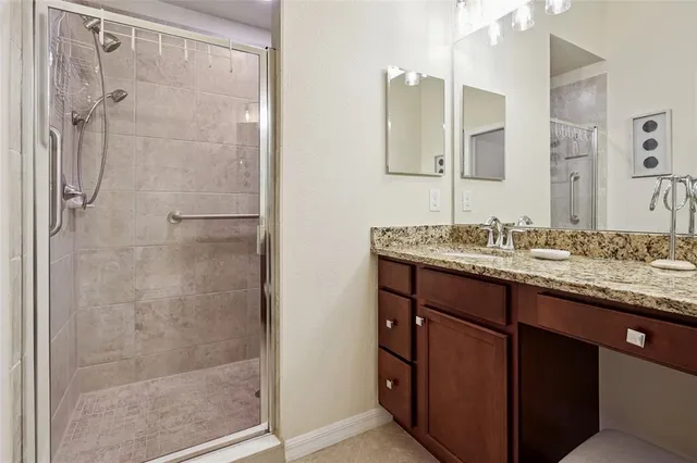 a bathroom with a granite countertop shower sink and mirror