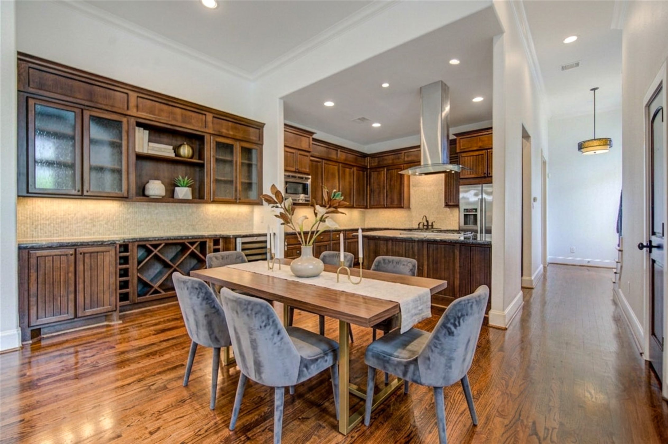 6520 Rodrigo Street Houston, TX 77007 - Photo 5 of 44 Open-concept kitchen with extensive custom built-ins, wine storage, beverage cooler, hardwood floors, and oversized island. Digitally Staged.