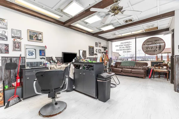 a living room with furniture a flat screen tv and kitchen view