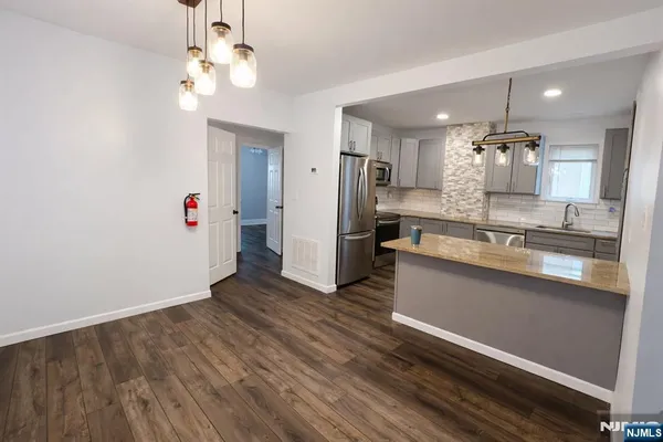 a kitchen with stainless steel appliances granite countertop a refrigerator and a sink