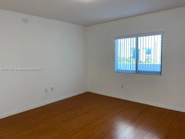 a view of a small space with wooden floor and a window