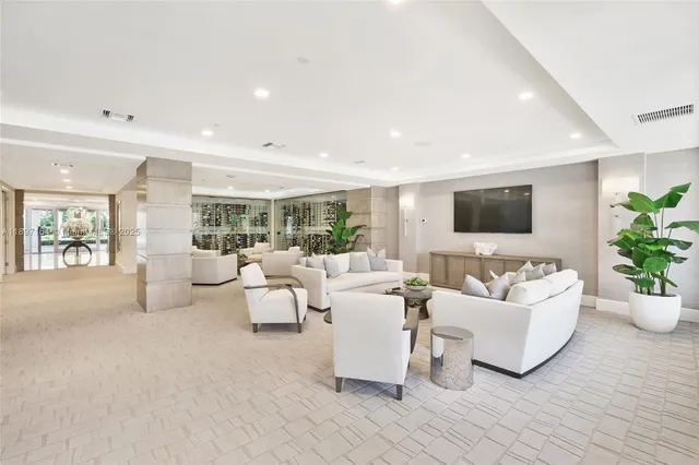 a living room with furniture a flat screen tv and a potted plant