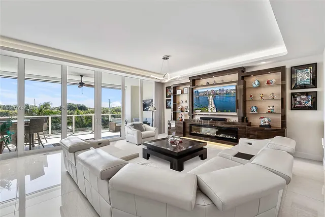 a living room with furniture large windows and a flat screen tv