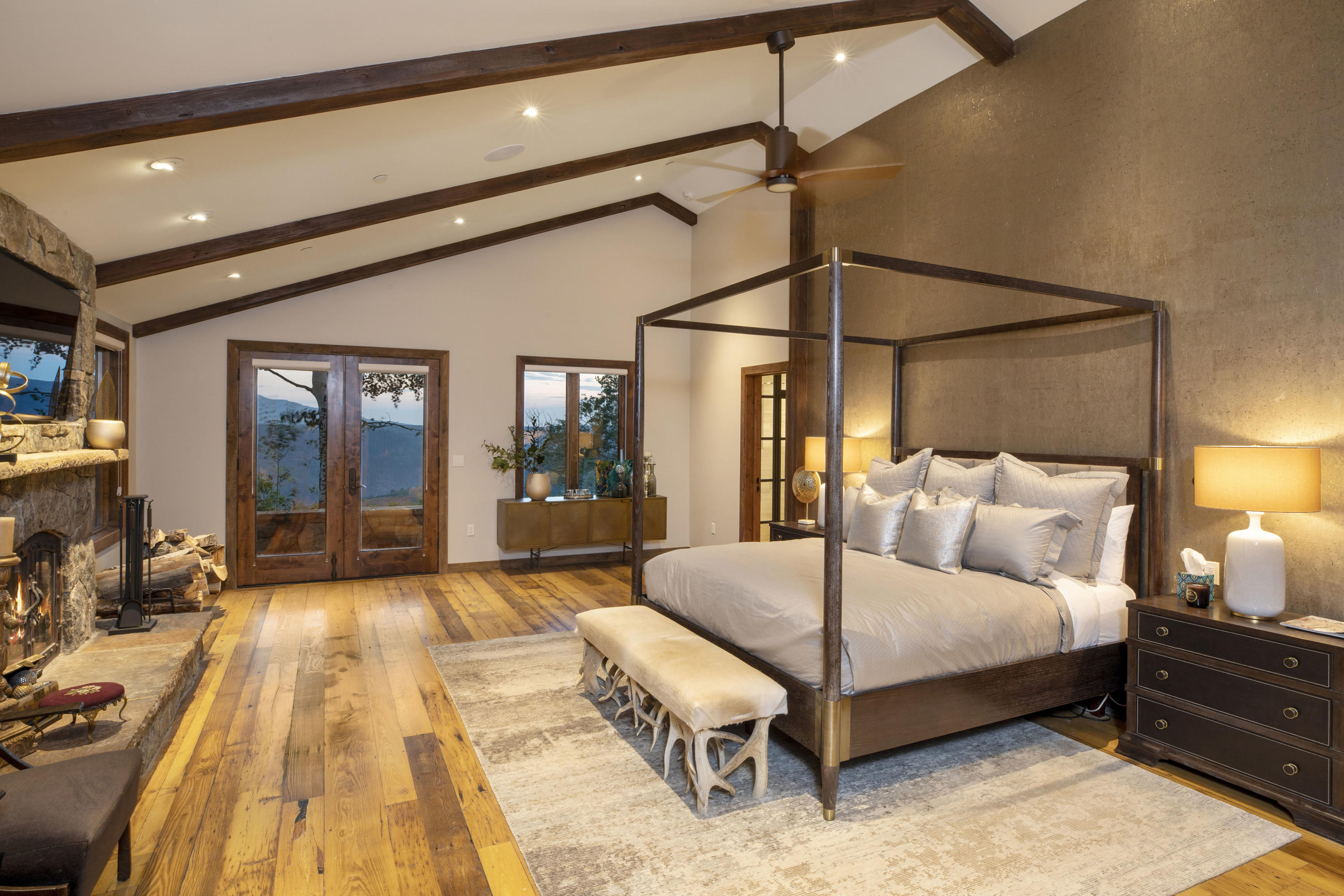 7039 Last Dollar Road Telluride, CO 81435 - Photo 19 of 52 a spacious bedroom with a large bed and a chandelier