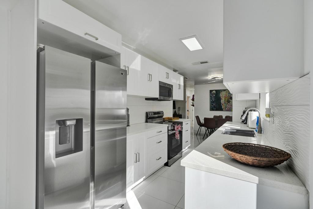1050 Northeast 150th Street Miami, FL 33161 - Photo 16 of 50 a kitchen with a sink appliances and cabinets