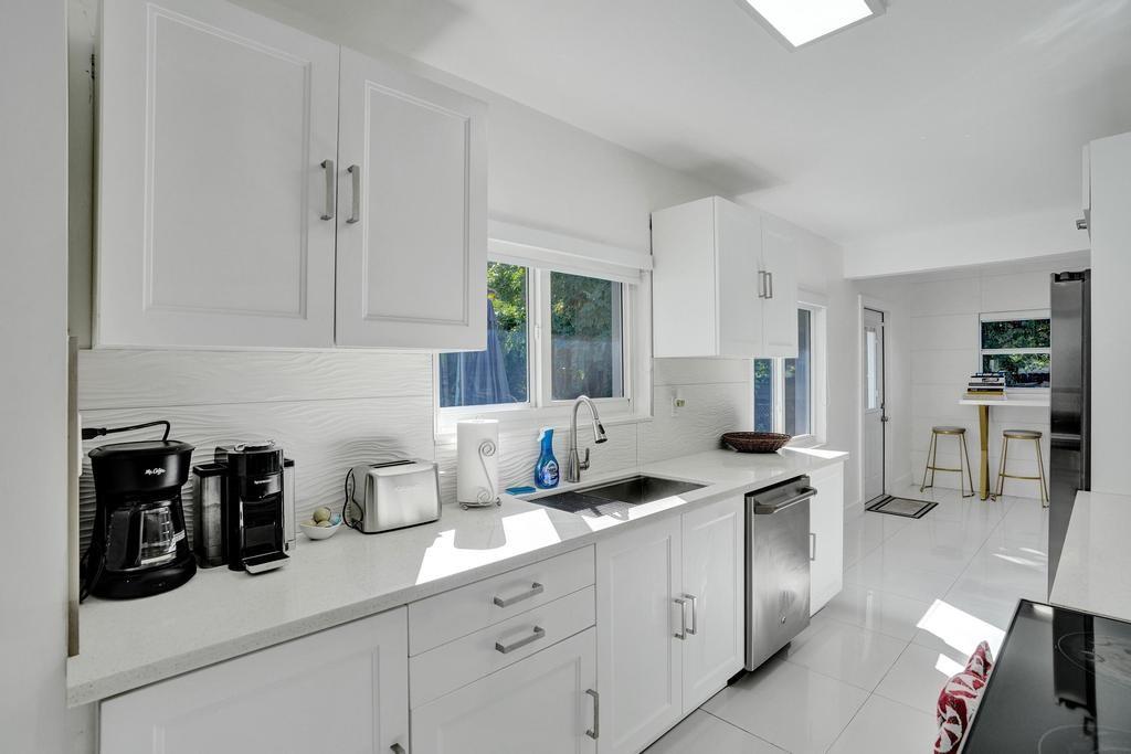 1050 Northeast 150th Street Miami, FL 33161 - Photo 18 of 50 a kitchen with stainless steel appliances granite countertop white cabinets and a refrigerator
