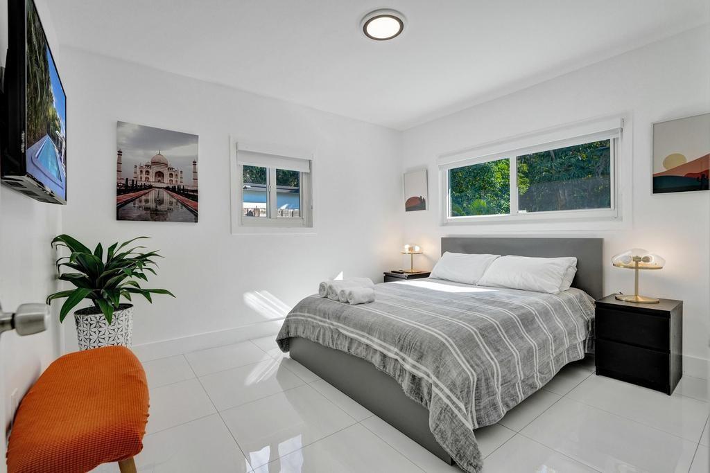 1050 Northeast 150th Street Miami, FL 33161 - Photo 19 of 50 a bedroom with a bed lamp and a potted plant