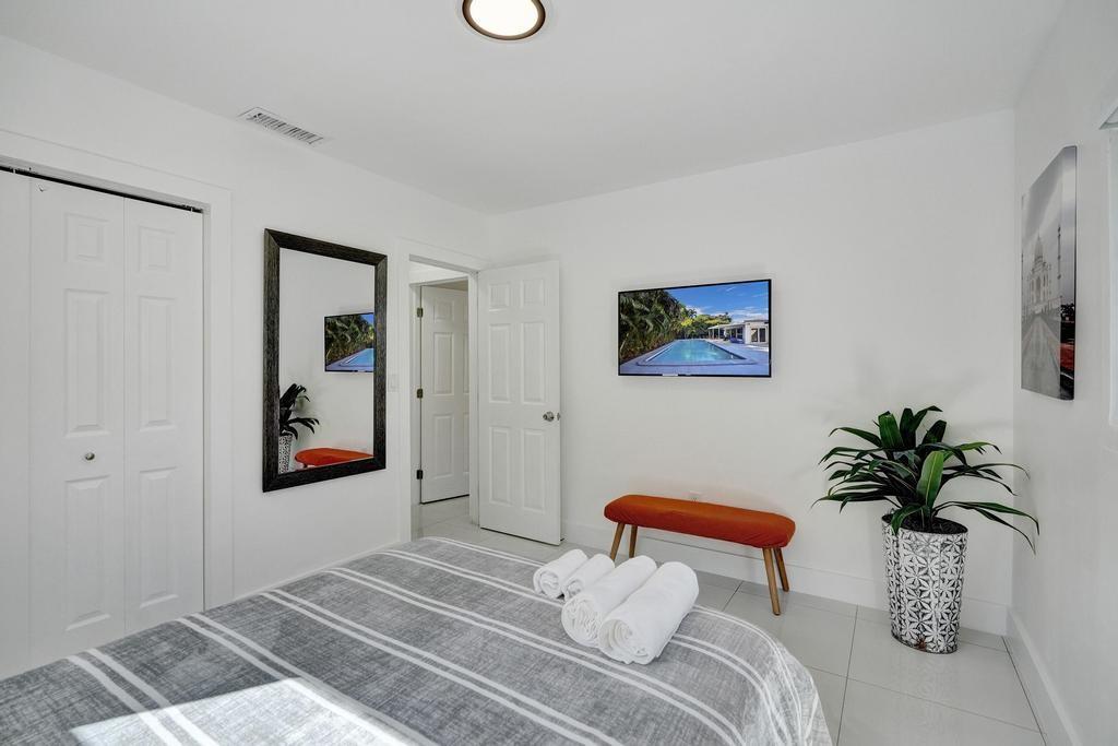 1050 Northeast 150th Street Miami, FL 33161 - Photo 21 of 50 a bedroom with a bed a potted plant and a window
