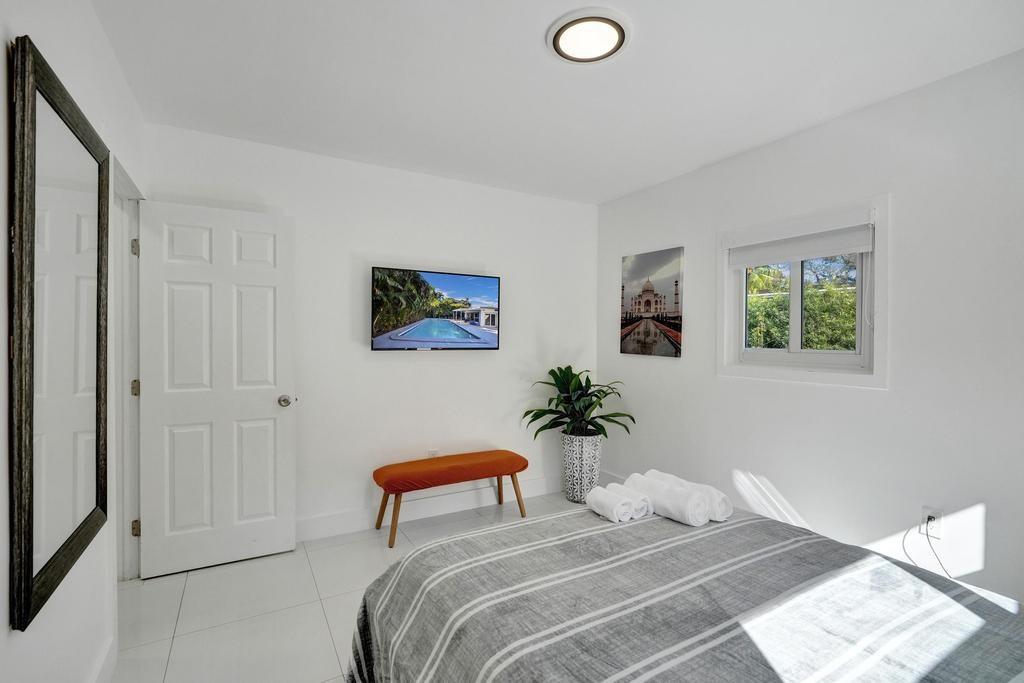 1050 Northeast 150th Street Miami, FL 33161 - Photo 22 of 50 a bedroom with a bed and a painting on the wall