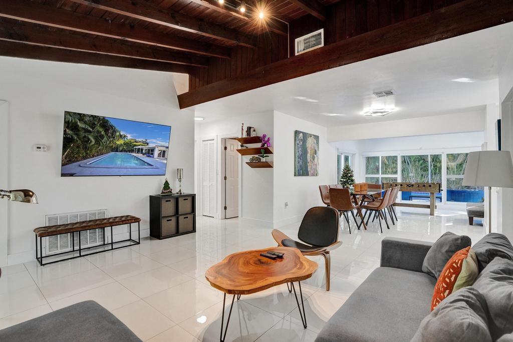 1050 Northeast 150th Street Miami, FL 33161 - Photo 10 of 50 a living room with furniture and a chandelier