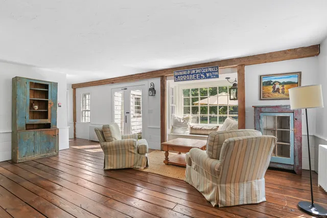 a living room with furniture and two large window