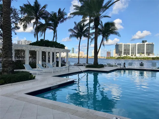a view of swimming pool with seating area and trees around