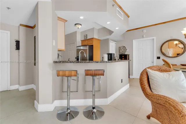 a kitchen with stainless steel appliances kitchen island granite countertop a table and chairs in it