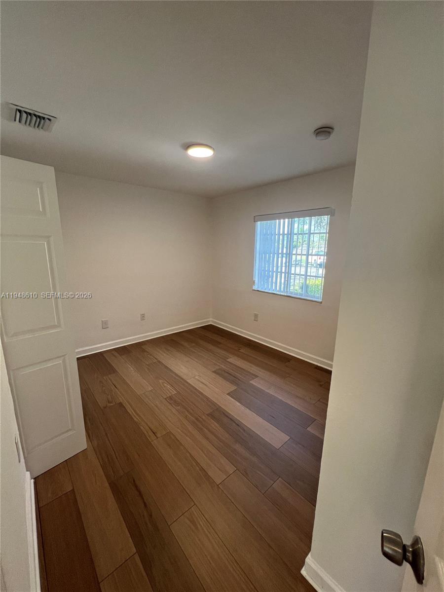 12254 Southwest 217th Street Miami, FL 33170 - Photo 13 of 40 an empty room with wooden floor and windows