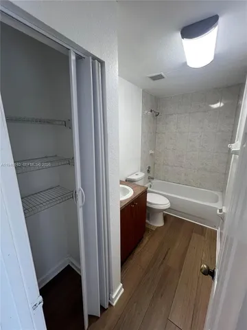 an empty room with wooden floor and closet