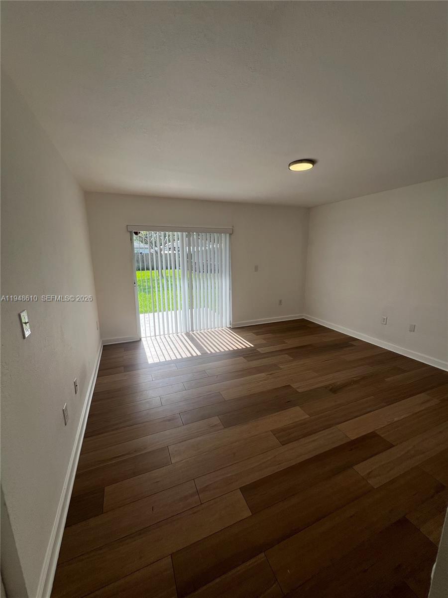 12254 Southwest 217th Street Miami, FL 33170 - Photo 22 of 40 an empty room with wooden floor and windows