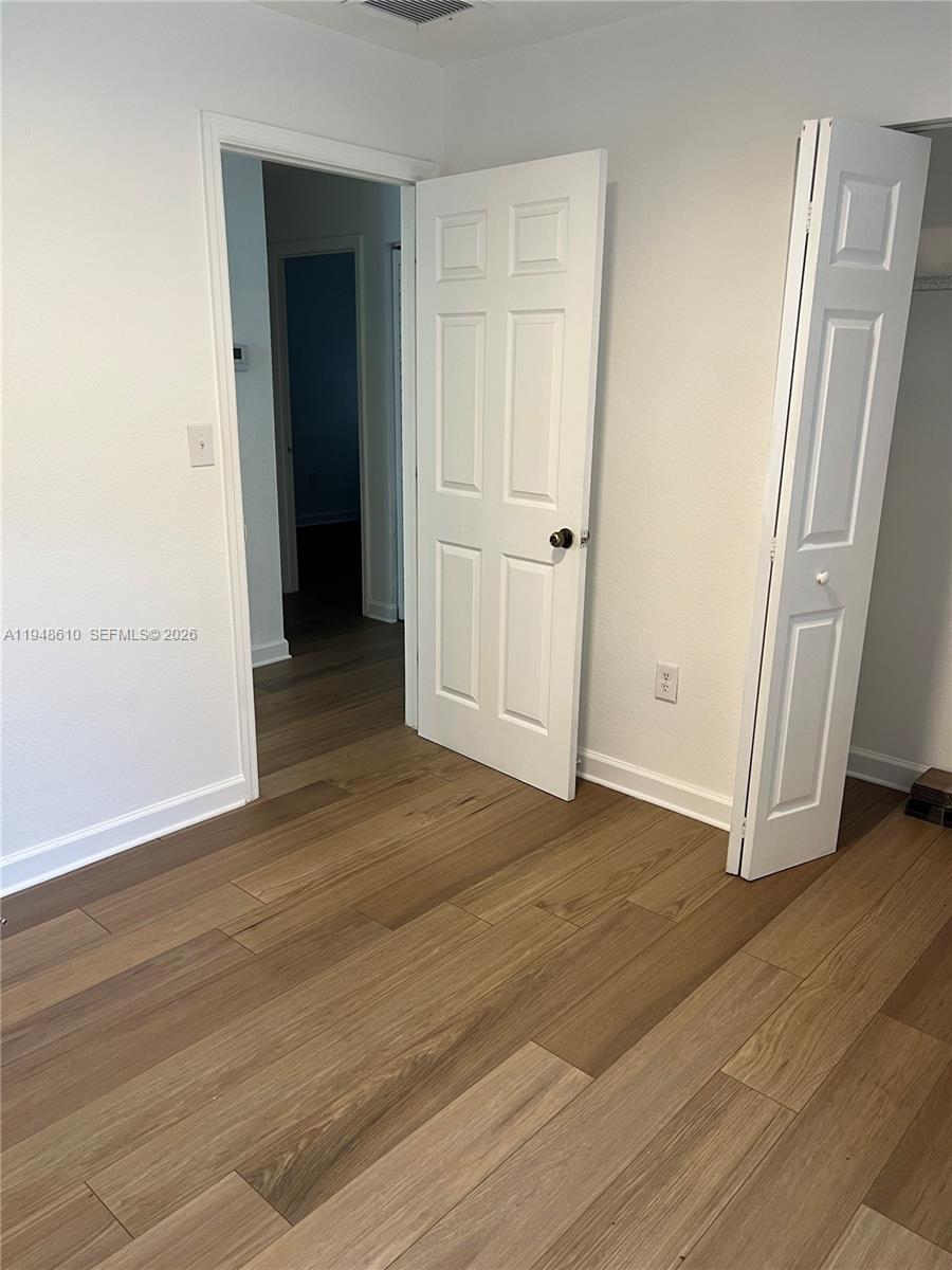 12254 Southwest 217th Street Miami, FL 33170 - Photo 28 of 40 an empty room with wooden floor and closet